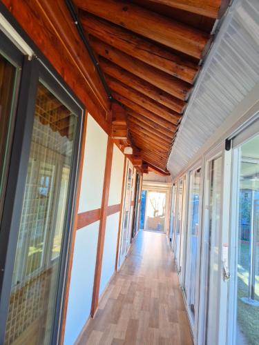 a hallway of a house with wooden ceilings and windows at Sunset Hanok Stay in Suncheon
