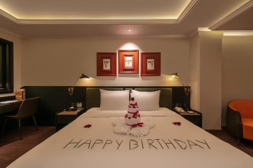 a bed with a happy birthday sign on top of it at Champton Hanoi Hotel in Hanoi