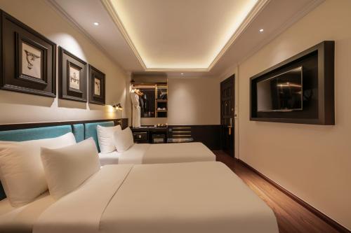 a hotel room with two beds and a television at Champton Hanoi Hotel in Hanoi