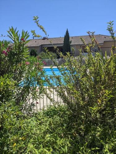 une clôture en face d'une cour avec une piscine dans l'établissement carré de détente JACUZZI JARDIN PISCINE T3 PARKING, à Castelnau-dʼEstrétefonds