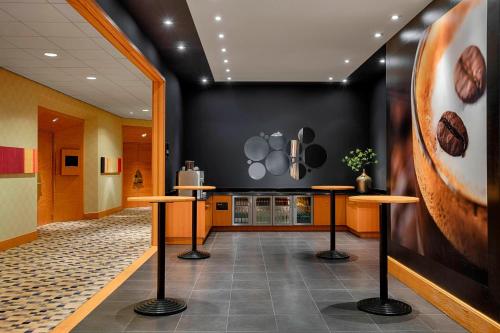 a kitchen with stools and a wall with pots and pans at Sheraton Brussels Airport Hotel in Zaventem
