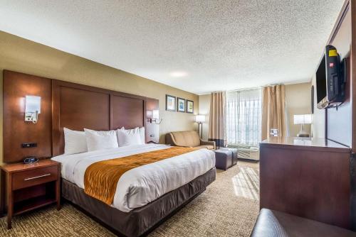 a hotel room with a large bed and a television at Comfort Inn & Suites Dayton North in Dayton