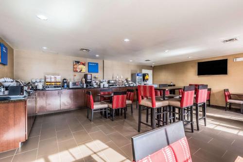 a restaurant with tables and chairs and a bar at Comfort Inn & Suites Dayton North in Dayton