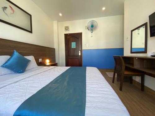 a bedroom with a bed and a desk and a desk at Hotel Hoàng Hưng Quy Nhơn in Quy Nhon