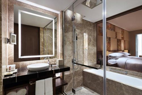a bathroom with a sink and a shower and a tub at Sheraton Grand Bengaluru Whitefield Hotel & Convention Center in Bangalore