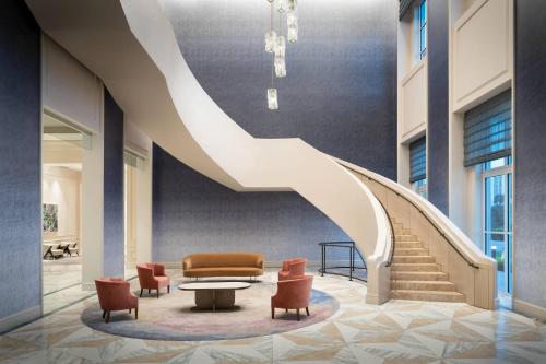 a staircase in a lobby with chairs and a table at JW Marriott Miami Turnberry Resort & Spa in Aventura