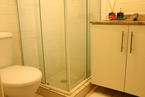 a bathroom with a toilet and a glass shower at Flats em frente ao Allianz Parque - HOTEL EM PERDIZES in Sao Paulo
