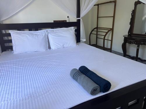 a bed with two rolled up towels on it at Birds Nest 2 in Bandaramulla