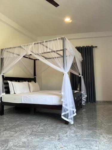 a bed with a canopy in a room at Birds Nest 2 in Bandaramulla
