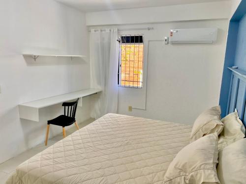 a white bedroom with a bed and a chair at Loft Aconchegante Apartamento Floripa 12 - Wi-fi 600Mb in Florianópolis