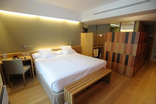 a bedroom with a bed and a desk with a chair at Hotel Continental Balneario de Panticosa in Panticosa