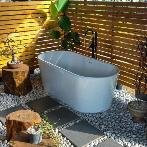 a white bath tub with a potted plant in it at Cozy Tiny Home with Outdoor Hot Tub in City Center in Davao City