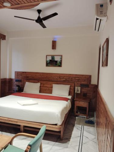a bedroom with a bed and a ceiling fan at Hotel CM Palace - Pure Vegetarian in Ner Chowk