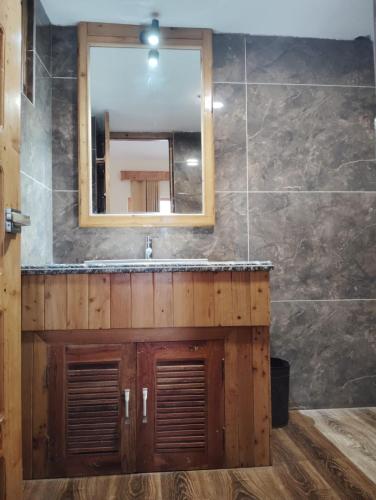 a bathroom with a sink and a mirror at Hotel CM Palace - Pure Vegetarian in Ner Chowk
