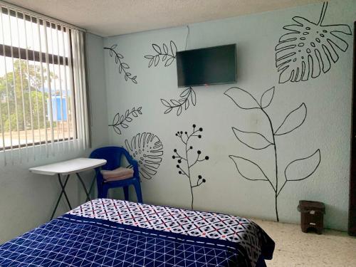 a bedroom with a bed and a tv on the wall at Departamento céntrico compartido in Pachuca de Soto