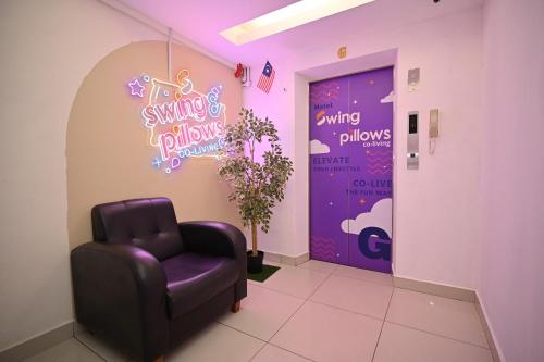 a waiting room with a chair and a waiting room window at Swing & Pillows - KL Sri Petaling in Kuala Lumpur