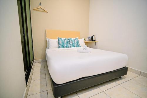 a large white bed in a room with at Swing & Pillows - KL Sri Petaling in Kuala Lumpur