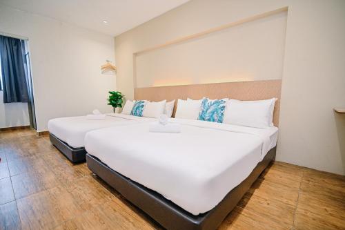 two large white beds in a room at Swing & Pillows - KL Sri Petaling in Kuala Lumpur