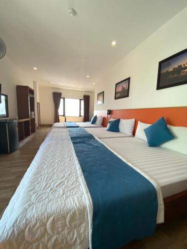 a row of beds in a hotel room at Hotel Hoàng Hưng Quy Nhơn in Quy Nhon