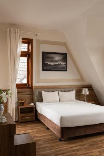 a bedroom with a large white bed and a window at Moon Valley Villas Đà Lạt in Xuan An