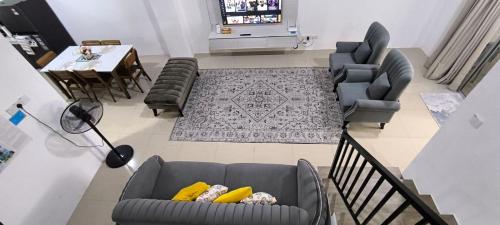 a living room with two couches and a dining room at AMI Homestay & Guest House in Gua Musang