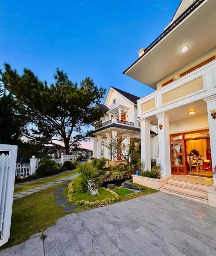 a large white house with a driveway at Moon Valley Villas Đà Lạt in Xuan An
