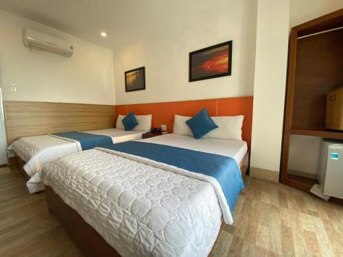 a hotel room with two beds in it at Hotel Hoàng Hưng Quy Nhơn in Quy Nhon