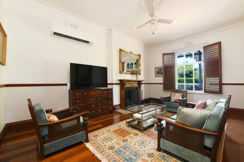 a living room with a fireplace and a tv at Currawong House in Maleny
