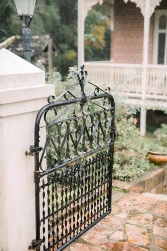 a black iron gate in front of a house at Currawong House in Maleny