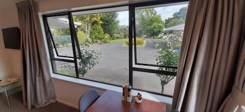 a window in a room with a desk and a view of a street at Studio 2369 in Te Awamutu