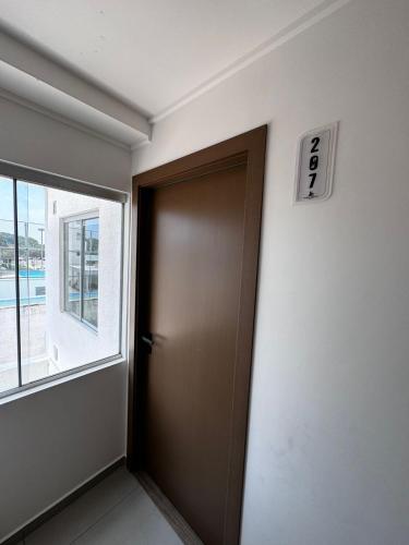 a brown door in a room with a window at Menacho Apartamento - Mangales Blue Norte in Santa Cruz de la Sierra