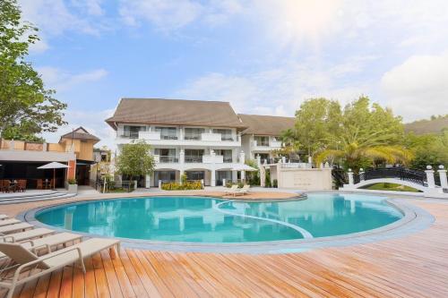 a swimming pool in front of a house at Pinnacle Grand Jomtien Resort and Beach Club in Na Jomtien