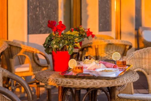 a table with a tray of food and a vase with red roses at Astura Palace Hotel in Nettuno