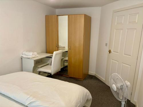 a bedroom with a bed and a desk and a chair at The Flat in Monmore Green