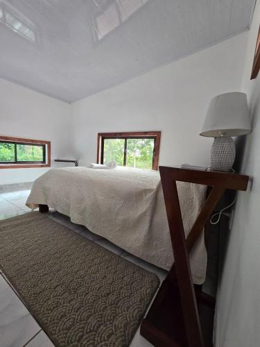 a bedroom with a bed and a table with a lamp at Happy Paradise Lodge in Nuevo Arenal