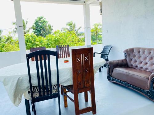 a room with a bed and a chair and a couch at Indika's Apartment in Hikkaduwa