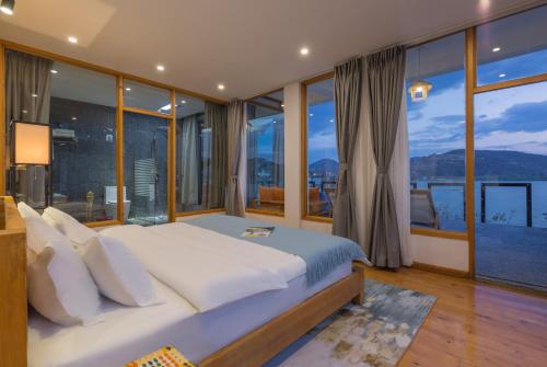 a bedroom with a large bed and large windows at Dali Muhai Island Designer Seaview Manor in Dali