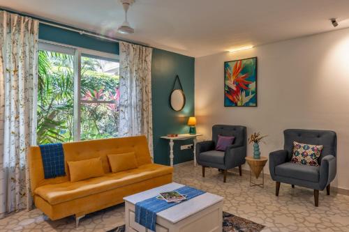 a living room with a couch and two chairs at Santa Tera Homely 1&2bhk Apartments With Common Pool & Kitchen & Security & Wifi, Near to Candolim in Verem