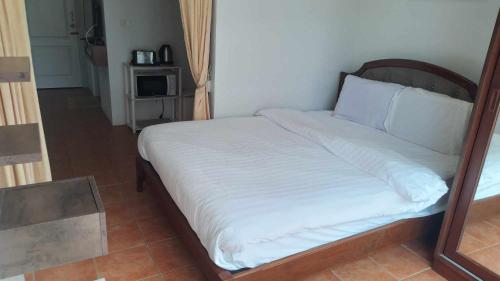 a bed with white sheets and a wooden frame at AvataraA B32 by malai in Ban Tha Fat