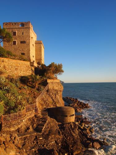 a building on a cliff next to the ocean at Zia Letizia Bed And Wine in Monterosso al Mare