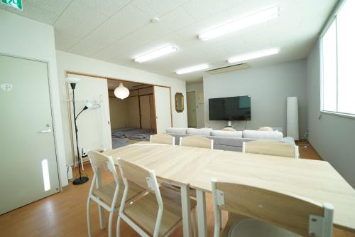 a room with a table and chairs and a tv at 浜ノ町瀬戸凪 in Takamatsu