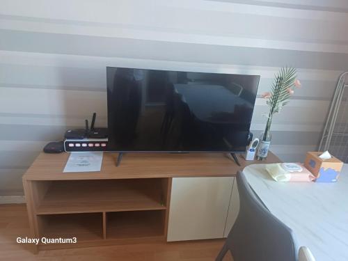 une télévision assise sur une table en bois à côté d'un lit dans l'établissement Hongdae Guesthouse2 1min from Hongik Uni station Exit #1, à Séoul