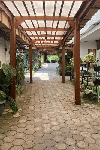 a patio with a wooden pergola with plants at Annet Homestay Yogyakarta in Balong