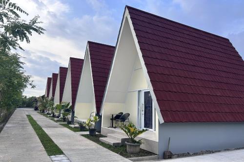 a row of houses with a red roof at Annet Homestay Yogyakarta in Balong