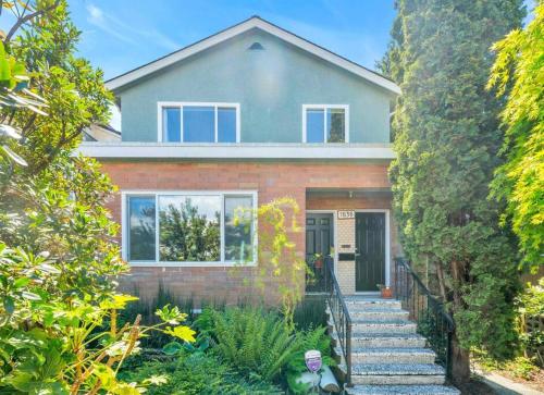 a house with a staircase in front of it at Charming East Van Home Near DT and Commercial St in Vancouver