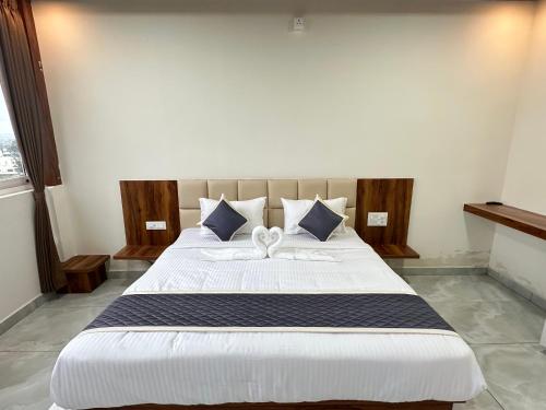 a bedroom with a large bed with white sheets and pillows at SS Luxury Comforts - Twin Sharing in Chikmagalūr
