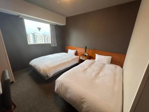 En eller flere senge i et værelse på Hotel Route-Inn Kanazawa Ekimae