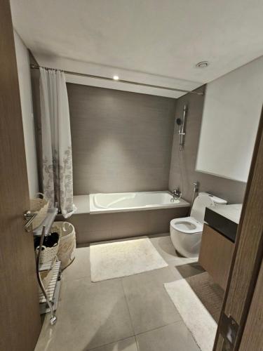 a bathroom with a bath tub and a toilet at Apartments 100 m2 in Sharjah