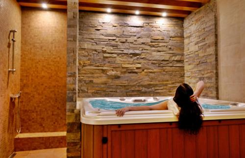 a woman laying in a hot tub in a bathroom at Dom Wczasowy Grań in Zakopane