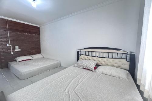 a bedroom with two beds in a room at Annet Homestay Yogyakarta in Balong
